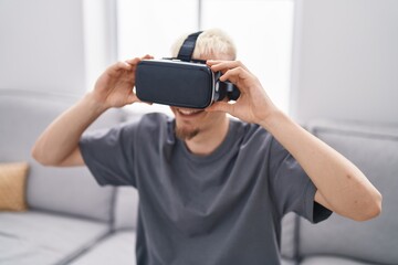 Young caucasian man using virtual reality glasses at home