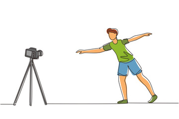 Single one line drawing young man doing exercise on mat with camera. Shooting video for blog on video camera. Online training. Sport at home. Continuous line draw design graphic vector illustration
