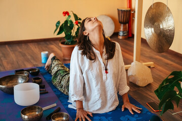 girls on a yoga class. Girls doing yoga and breathing practices Tibetan singing bowl in sound...