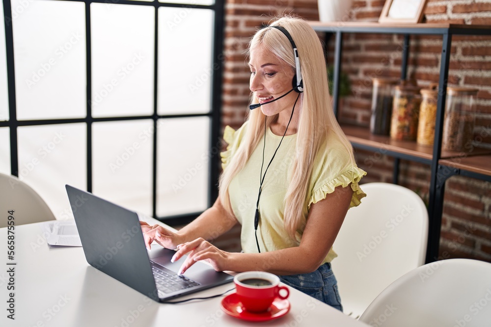 Wall mural young blonde woman call center agent working at home