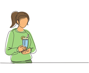 Single one line drawing woman holding glass with delicious milkshake. Young girl holding tasty fresh milk shake with slice of orange. Modern continuous line draw design graphic vector illustration