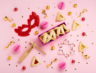 Hamantaschen Cookies, Red Carnival Mask, Noisemaker on Pink Background. Purim Celebration, Jewish Carnival Holiday Concept.