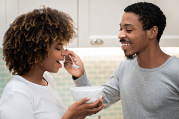 Closeup of african american man feeding his pretty girlfriend