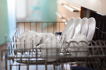 Closeup Shot Of Open Built-in Dishwasher Machine With Clean Dishes