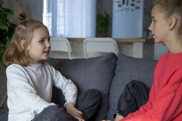 A teenage girl and her sister look at each other, share secrets and mysteries. The concept of warm...