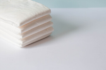 A stack of disposable diapers on the changing table. Space for text.