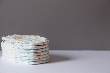 A stack of diapers on the changing table. Space for text.