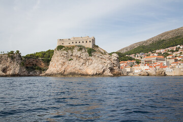 Fototapeta na wymiar Seaside view to Fort Lovrijenac and the wall surrounding the old town of Dubrovnik, Croatia - one of the best preserved fortification systems in Europe