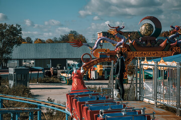 An old amusement ride in an abandoned amusement park. Abandoned carousel and cars. Sunny day. Old...