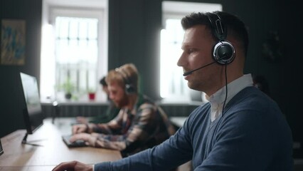 serious man answering customer call in tech support service, portrait in office of call-center