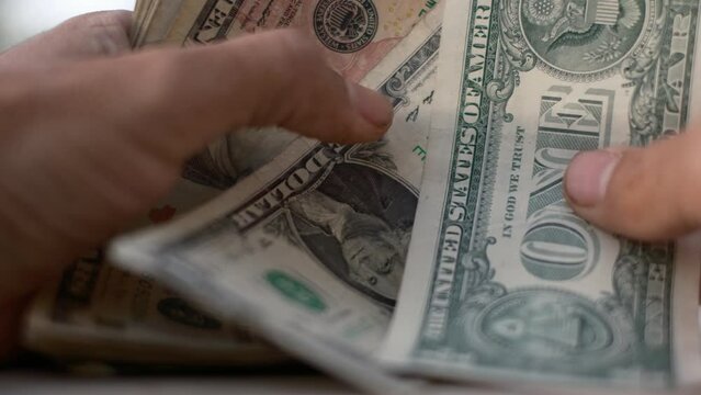 close up of hands counting assorted dollar bills concept money finance debt economy