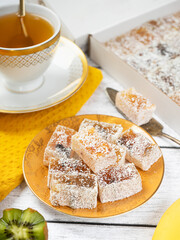Pleasant tea drinking: a cup of freshly brewed tea and a sweet treat on a side table. Small bars of Turkish delight marmalade. fruit treat