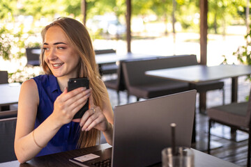 a girl sits on a summer terrace and works at a laptop. freelance. selfeducation. the concept of...