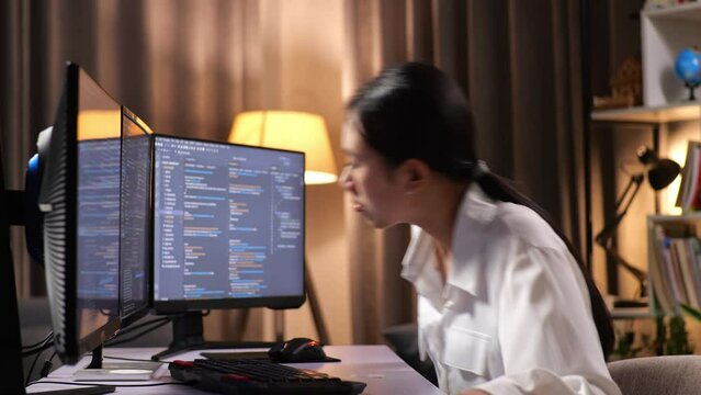 Asian Woman Programmer Walking Into The Working Space Before Sitting To Creating Software Engineer Developing App, Program, Video Game On Desktop Computer At Home
