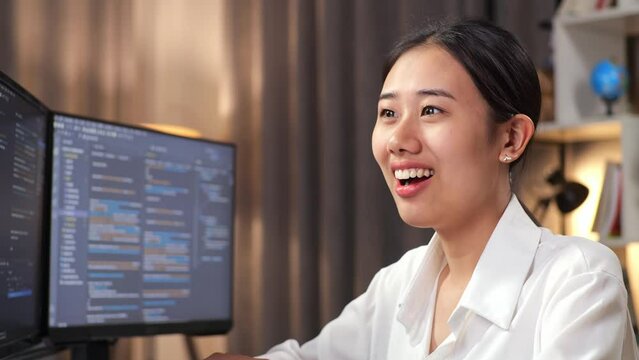 Close Up Of Asian Woman Programmer Smiling And Crossing His Arms While Creating Software Engineer Developing App, Program, Video Game On Desktop Computer At Home
