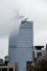 Fototapeta premium Wolkenkratzer aus Stahl, Beton und Glas in Wolken.