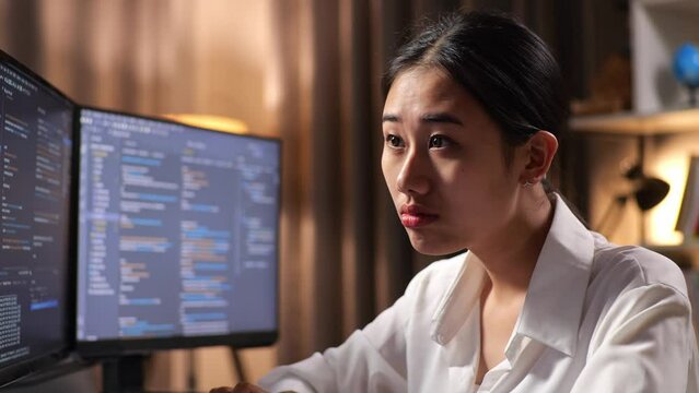 Close Up Of Asian Woman Programmer Yawning While Creating Innovative Software Engineer Developing App, Program, Video Game On Desktop Computer At Home. Terminal With Coding Language 

