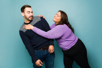 Young woman flirting with an upset caucasian man