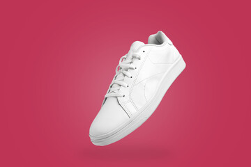 High angle view of white sneaker isolated on magenta (Viva Magenta) background. Sportive pair of shoes for mockup. Fashionable stylish sports casual shoes.