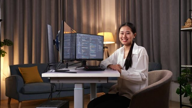 Asian Woman Programmer Smiling To Camera While Creating Software Engineer Developing App, Program, Video Game On Desktop Computer At Home. Terminal With Coding Language 
