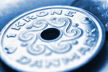 1 Danish krone coin close-up. National currency of Denmark. Blue tinted money illustration for news...