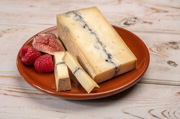 French semi-soft cow milk cheese morbier from Franche-Comte region with thin black layer and strong aroma