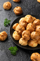 Savoury profiteroles stuffed with Molten cheddar cheese sauce, party food concept