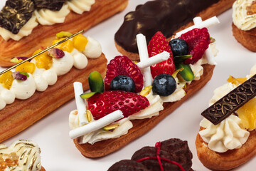 A tempting array of éclairs topped with fresh berries and rich chocolate, each a small work of edible art