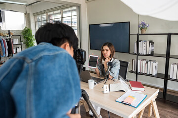 Videographer recording footage of female influencer in studio