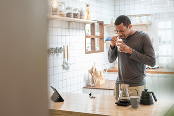 Happy Black African American male making coffee drip in kitchen, Hot drink, Barista at home, Preparing coffee.
