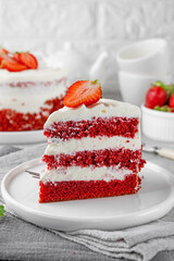Red velvet cake with fresh strawberries. Festive layered cake from red sponge cakes and cream cheese frosting, American cuisine.