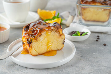 Homemade bread pudding with chocolate chips on a gray concrete background. Selective focus, copy space.