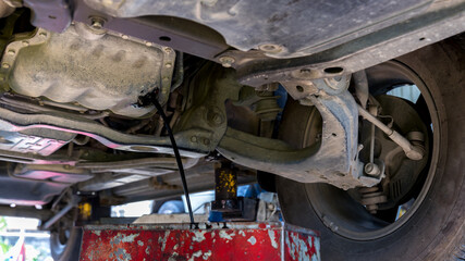 Drain the old oil from the engine through the drain plug. Changing the oil in a car engine. discharge of waste oil from motor car. Draining used diesel engine power from an oil pan into a container 