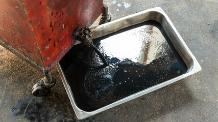 Old oil tray that was removed from the automobile. Old black oil lubrication engine vehicle motor...