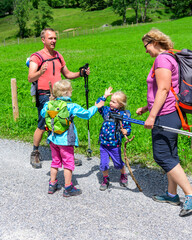 Gutgelaunte Familie freut sich über dan gelungenen Wanderausflug im Gebirge