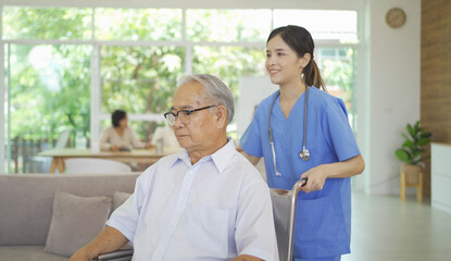 An Asian nurse talking to a group of old elderly patient or pensioner people smiling, relaxing, having fun together in nursing home. Senior lifestyle activity recreation. Retirement. Health care