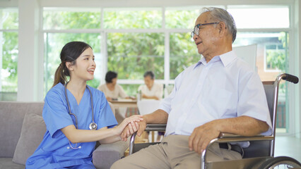 An Asian nurse talking to a group of old elderly patient or pensioner people smiling, relaxing, having fun together in nursing home. Senior lifestyle activity recreation. Retirement. Health care