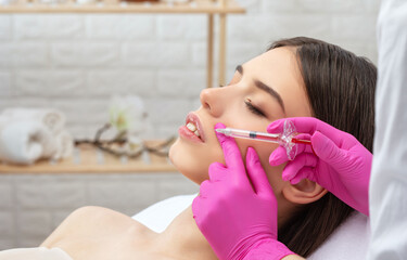 Injections for lips augmentation anti wrinkle injections on the face of a beautiful woman. Female...