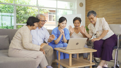 An Asian nurse talking to a group of old elderly patient or pensioner people smiling, relaxing, having fun together in nursing home. Senior lifestyle activity recreation. Retirement. Health care