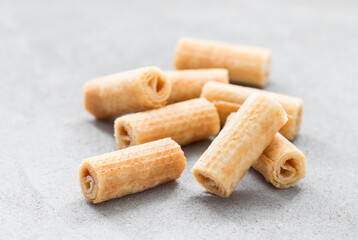Small waffle rolls. Light grey background. Closeup
