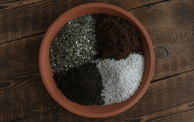 Soil components peat, bio humus, perlite, vermiculite on a clay tray. Soil mixture for growing flowers and vegetables.