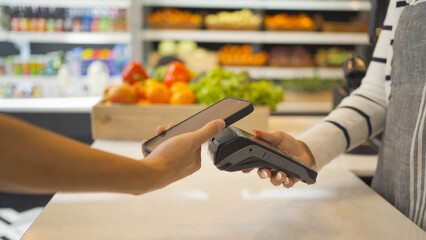 People shopping in a supermarket or retail shop, buying snacks and food by online credit card on...