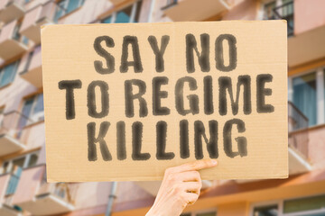 The phrase "Say No to Regime Killing " is on a banner in men's hands with blurred background. Oppression.  Change. Stand. Action. Rise. Tragedy. Stop.  Human. Empathy. Peaceful. Resist. Defend. Equal