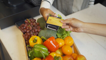 People shopping in a supermarket or retail shop, buying snacks and food by online credit card on mobile phone in cashier on grocery products shelves. Food shopping. People lifestyle.  Checkout service