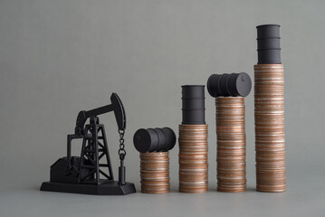 Crude oil tank on stack coin as price chart graph rising up and pump jack on grey background. World...