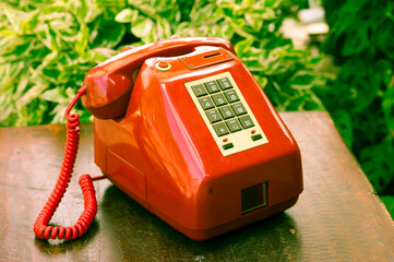 Old retro red telephone on table.