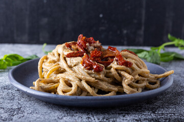 Spaghetti with ricotta cream and dried tomatoes, a typical Italian dish suitable for those who follow a vegetarian diet.