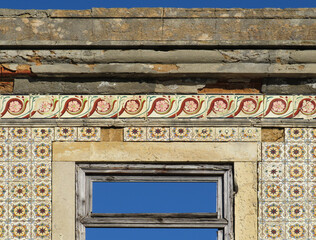 Detail of dilapidated house decorated with traditional revival tiles in the town of Almada. Lisboa. Portugal.