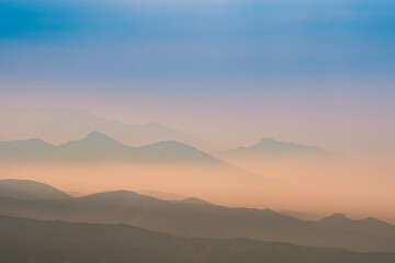 Fototapeta na wymiar A magical dawn over the Caucasus Mountains with layers of mountain ranges and a blue sky