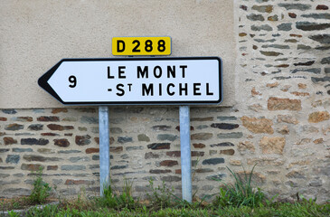 road sign with arrow to go to the famous Mont Saint Michel abbey in France